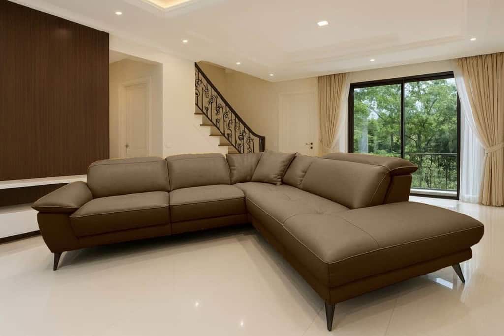 Zefio v hnědé kůži v rohu volně položené tři polštářky